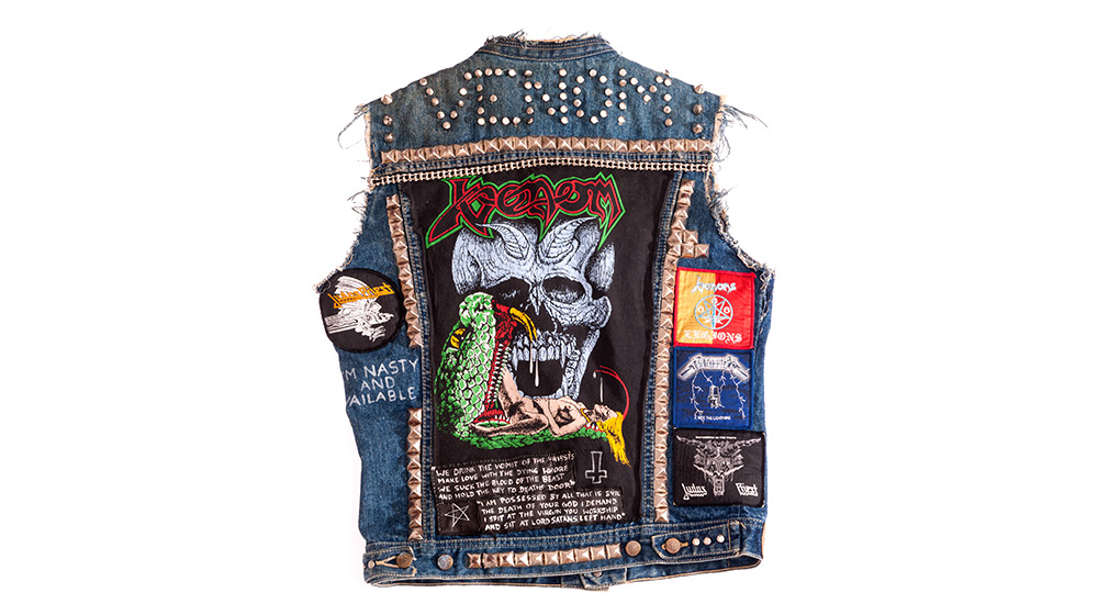 Jeans-Kutte mit aufgenähten Patches, Fransen an den Ärmeln und Nietenbesatz.