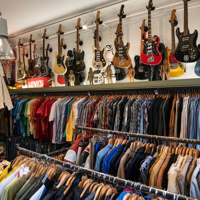 racks with vintage clothing ands vintage guitars